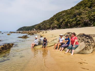Senior travellers relaxing on the beach in Abel Tasman