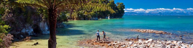 Walkers barefoot on the shore - Abel Tasman National Park Tours