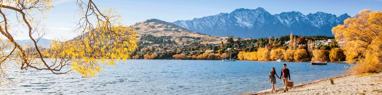 Couple walking along the lakeshore in autumn, Queenstown - NZ Sightseeing Itinerary